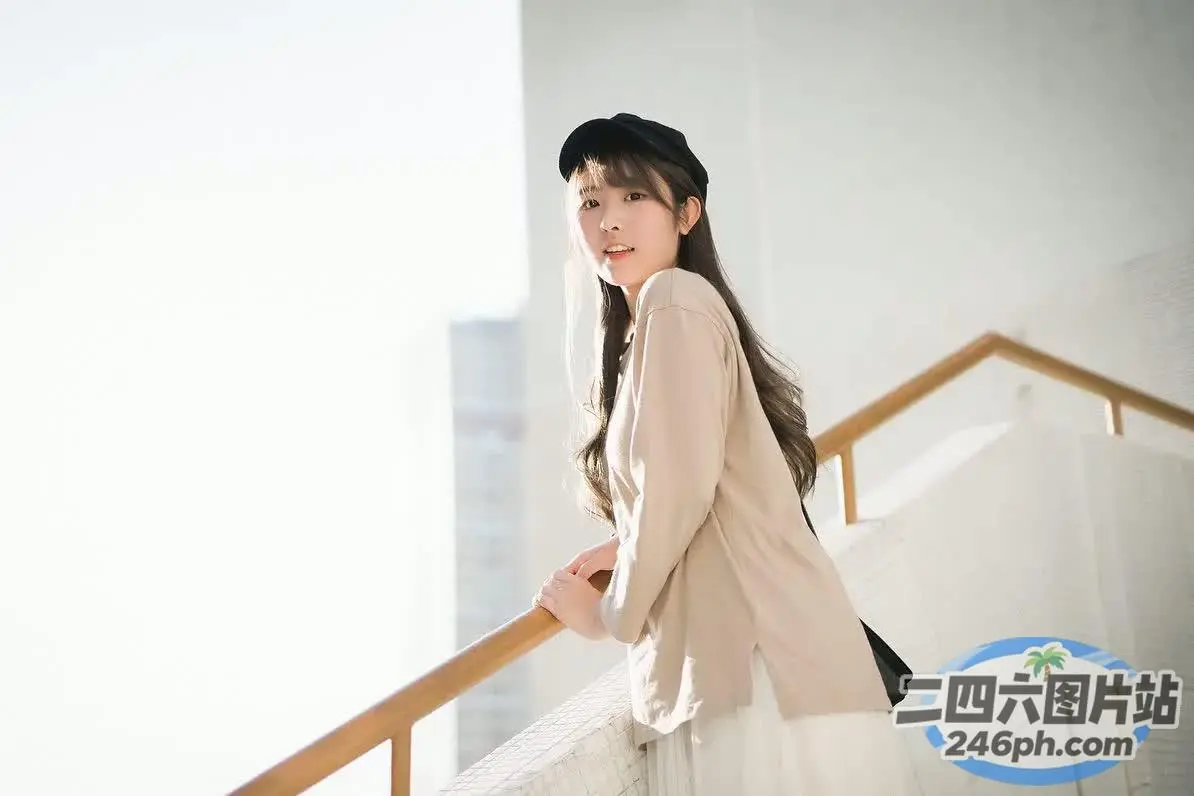 阳台上站着一个戴着帽子的女人