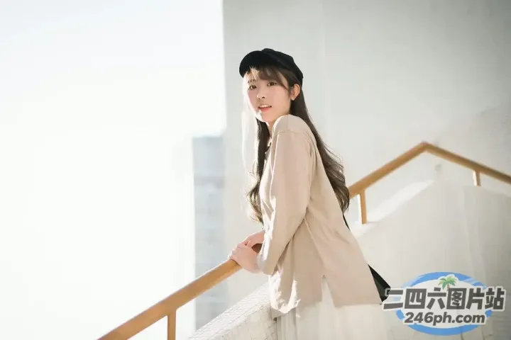 阳台上站着一个戴着帽子的女人