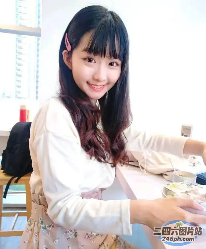 有个女人坐在一张桌子旁，桌上放着一盘食物