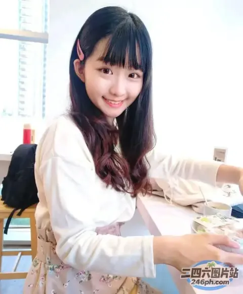 有个女人坐在一张桌子旁，桌上放着一盘食物