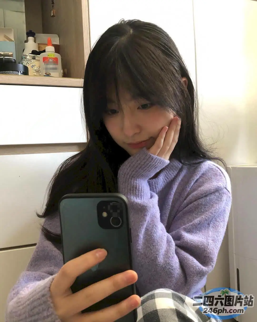 坐在地板上看手机的阿拉菲德女人
