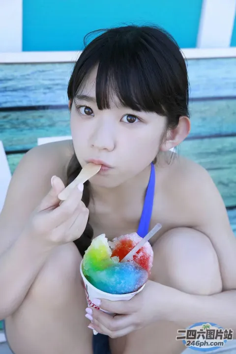 阿拉伯裔亚洲女子在海滩上吃一碗冰淇淋