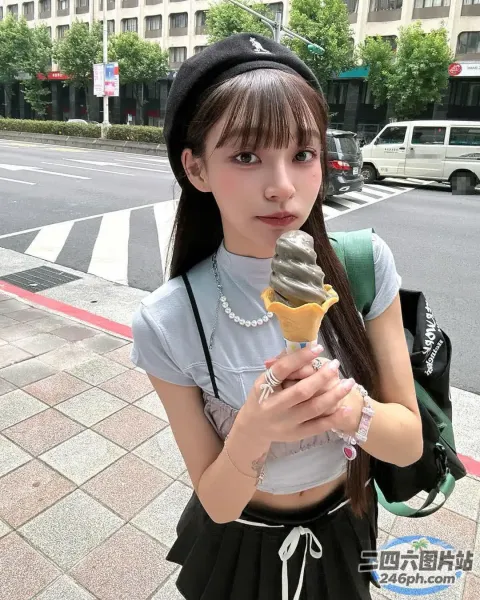 戴着黑色帽子和灰色衬衫的 Araffe 女孩，手里拿着一个冰淇淋甜筒