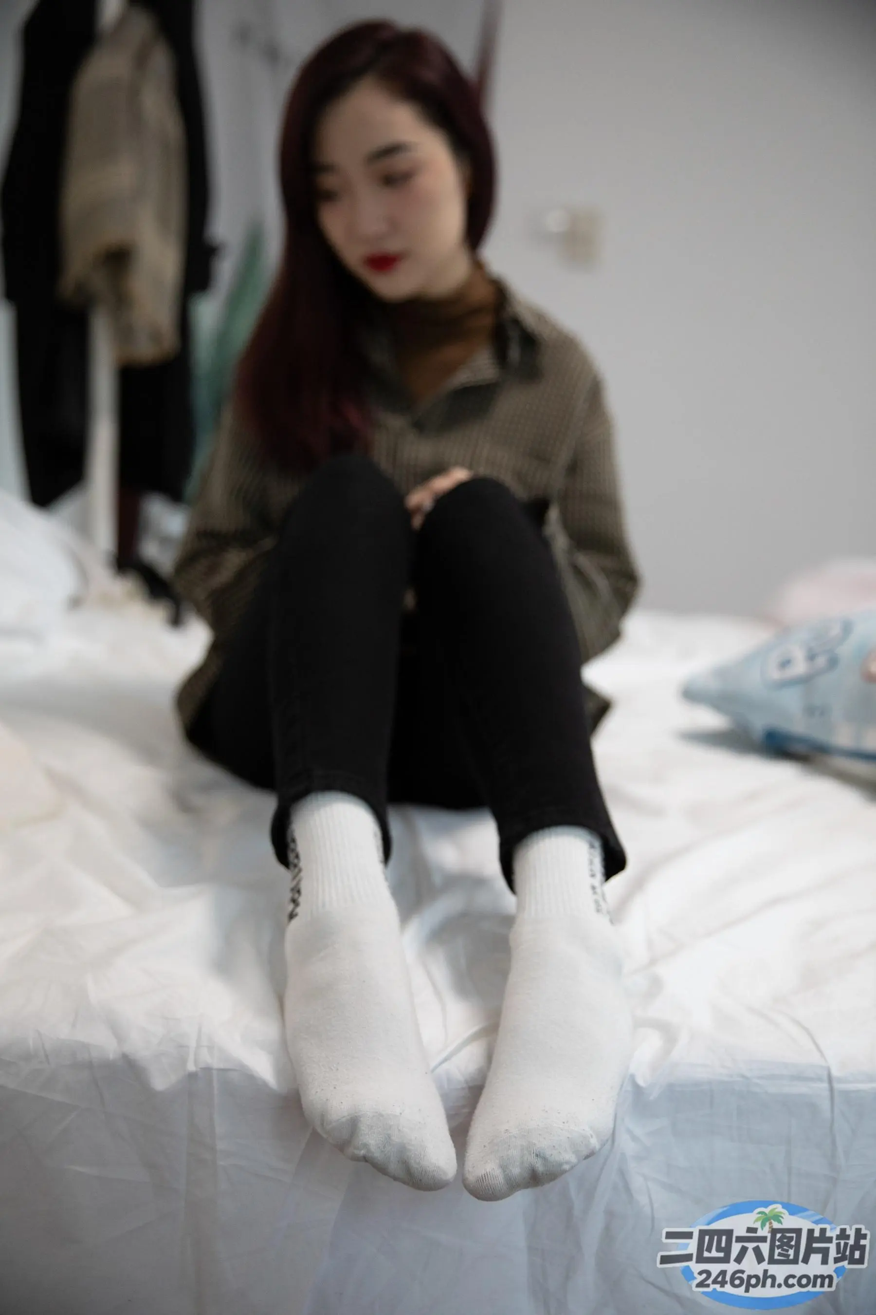 有一个女人坐在床上，双腿交叉