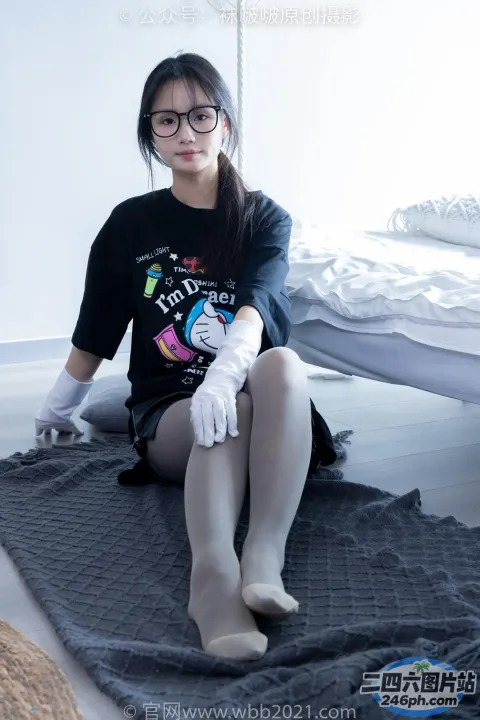 坐在床上的阿拉夫德女人，穿着黑色衬衫和白色手套