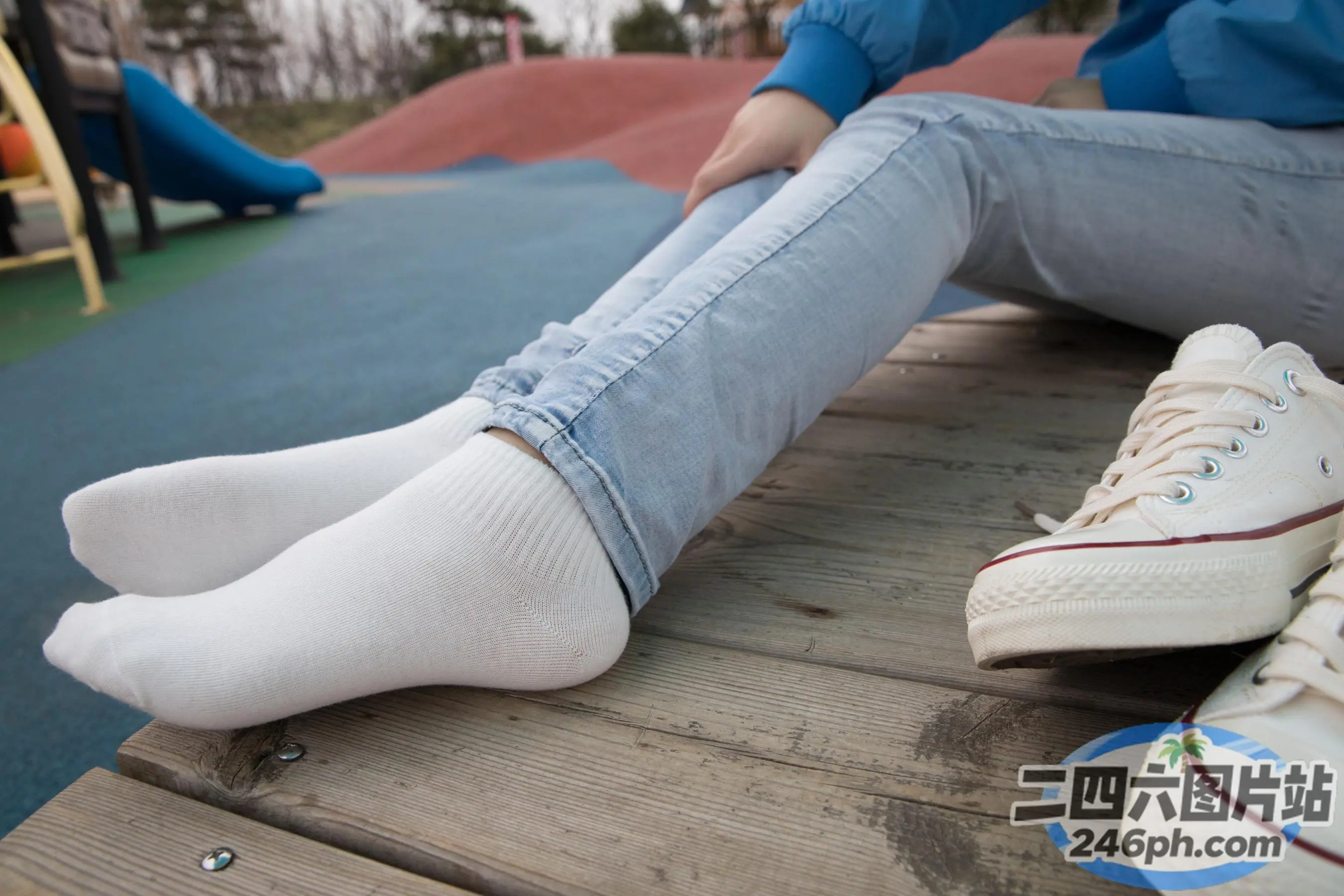有人坐在长凳上，双脚抬起，双叉