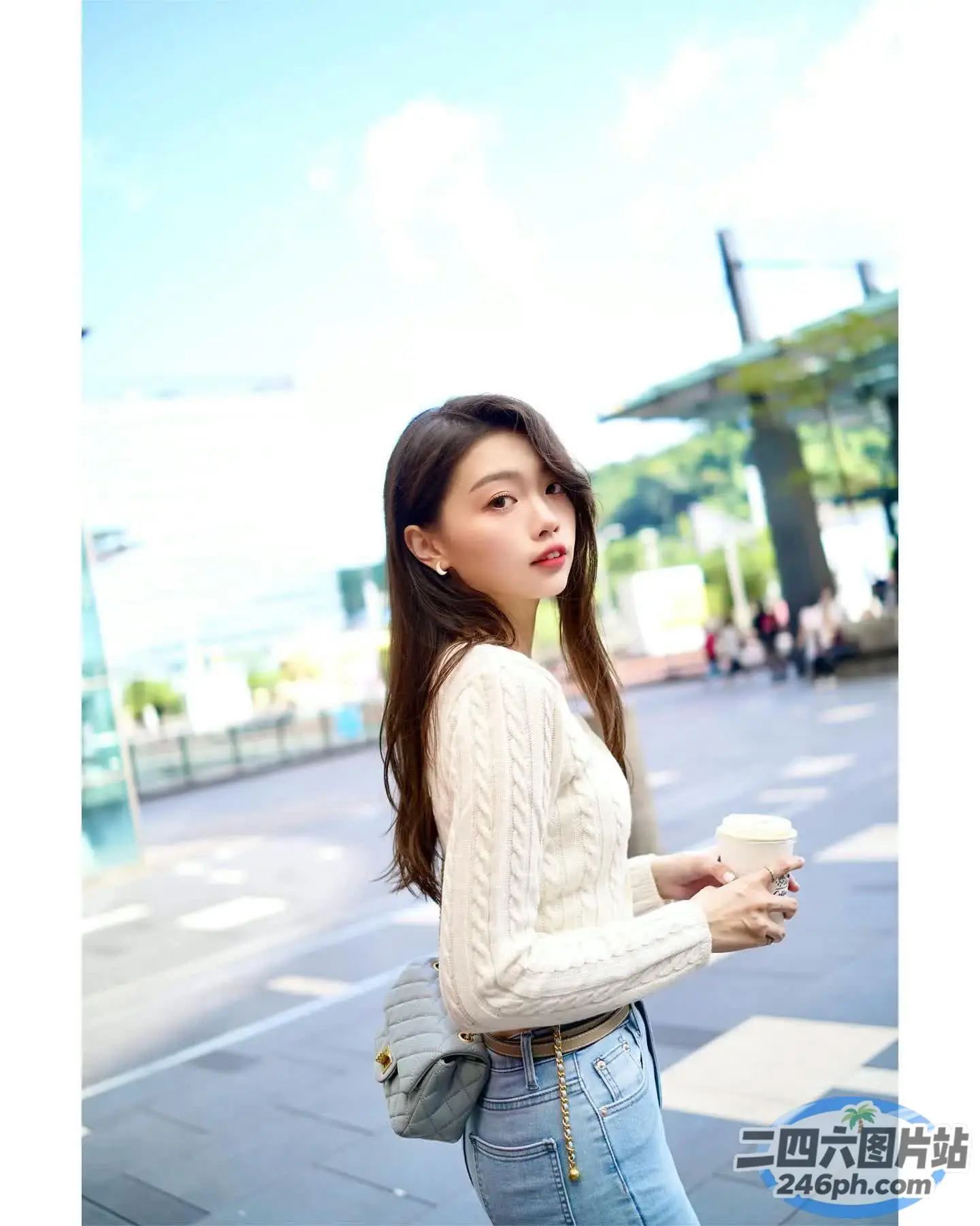 身穿白色毛衣和牛仔裤的 araffe 女子，手里拿着一杯咖啡
