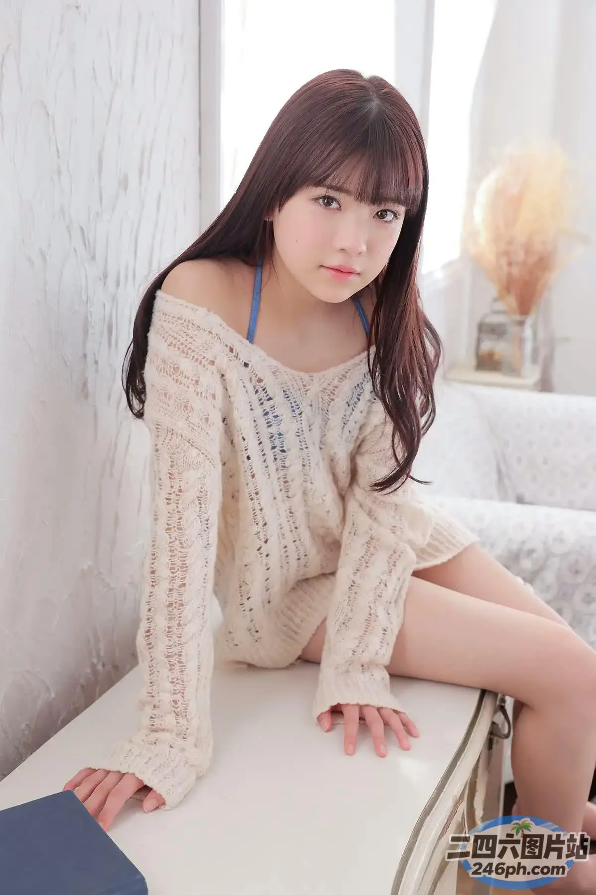 阿拉夫德亚洲妇女拿着笔记本电脑坐在白色桌子上