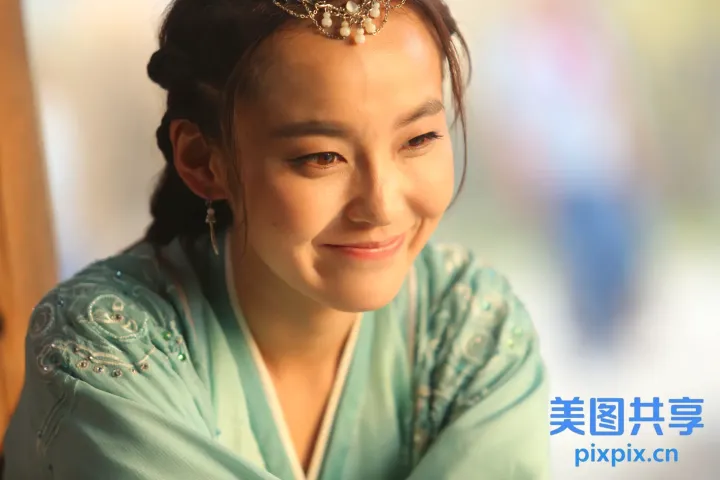 穿着绿色连衣裙的 arafed 女人微笑着看着镜头