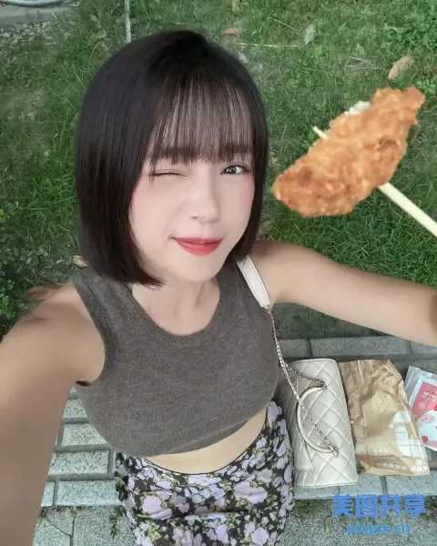穿着棕色衬衫和黑色裙子的 araffe 女孩，手里拿着一只炸鸡