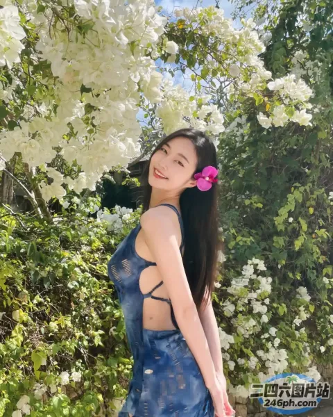 一个穿着蓝色连衣裙的女人站在树前的特写