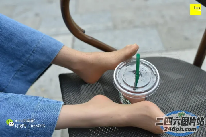 有人坐在椅子上，手里拿着一杯咖啡