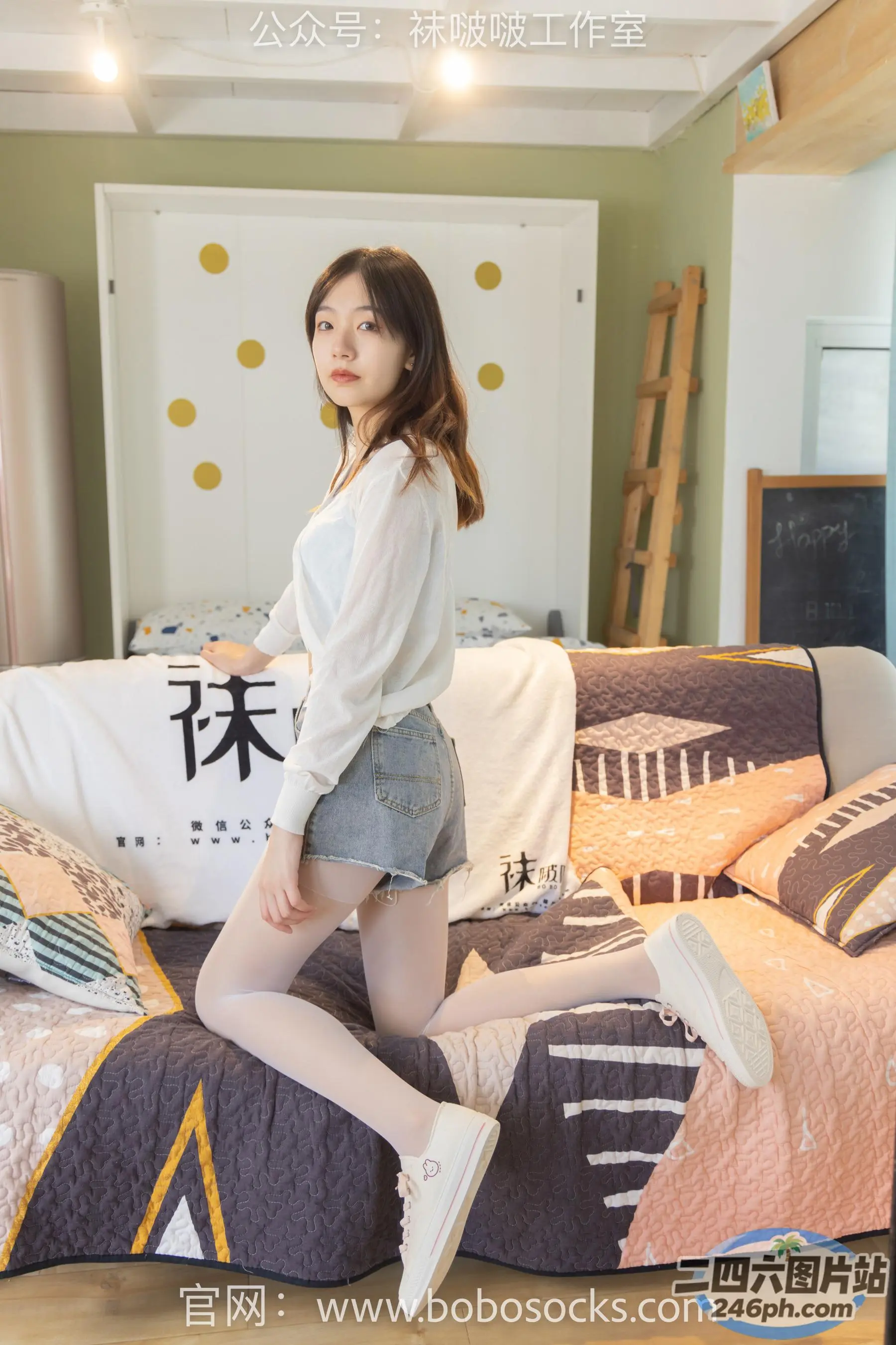 身穿白衬衫和牛仔短裤的 arafed 女子在床上摆姿势
