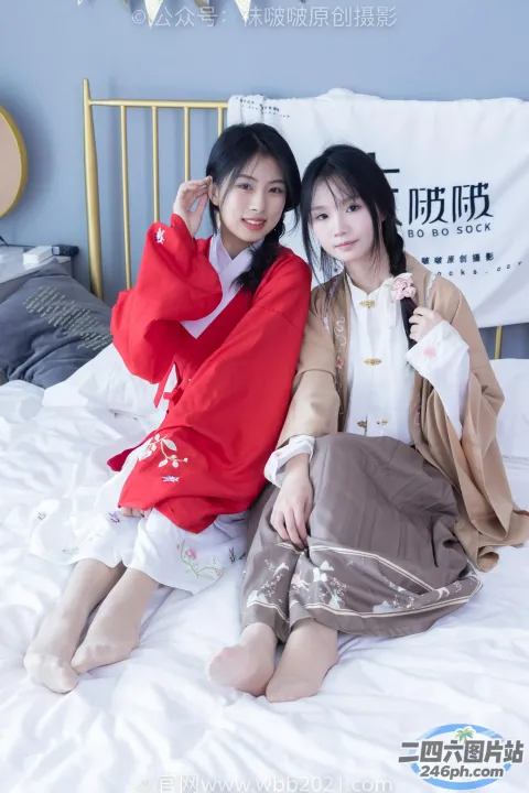 两名亚裔女性坐在卧室的床上