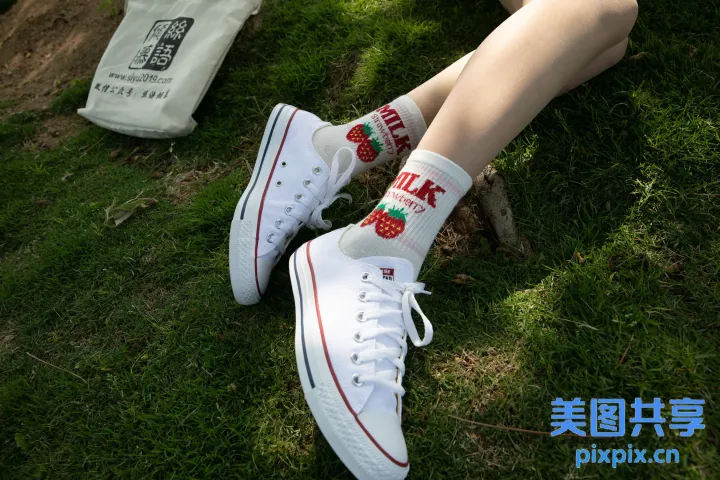 有人坐在草地上，双脚抬起，穿着鞋子