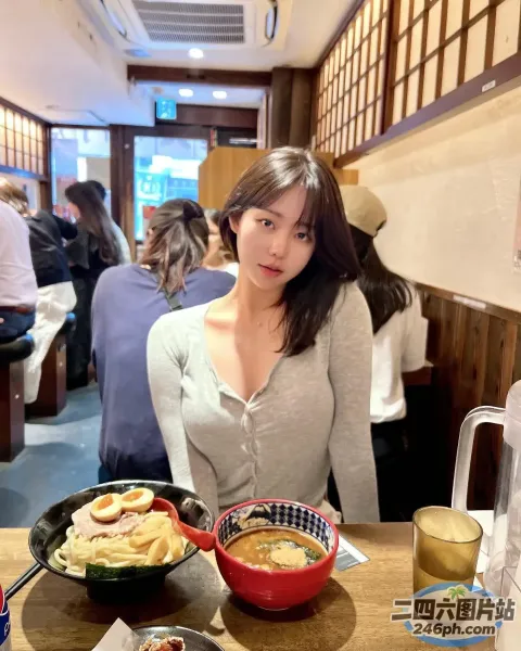 女人坐在桌子旁，手里拿着一碗食物和一碗汤