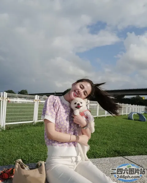 坐在地上的女人抱着一只小白狗