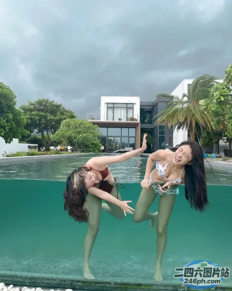 两名身穿比基尼的女子在游泳池附近的水中