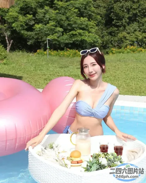 有一个穿着比基尼的女人坐在游泳池里，手里拿着一盘食物
