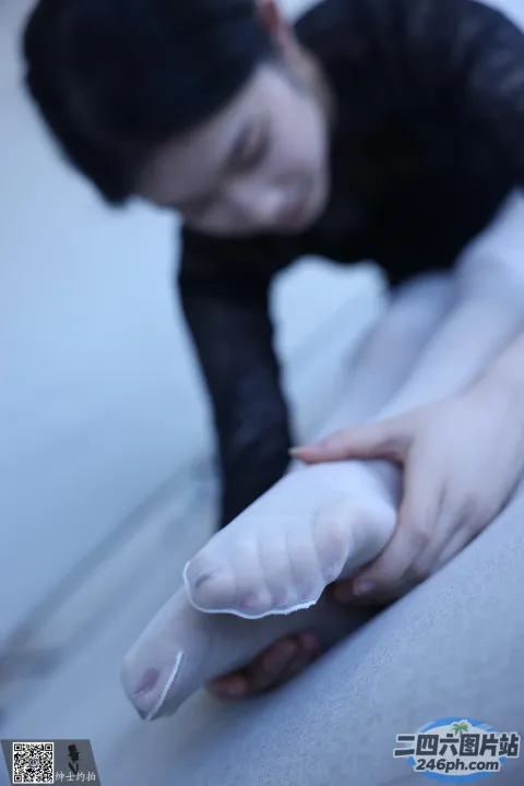 有人在沙发上手里拿着一个白色的物体