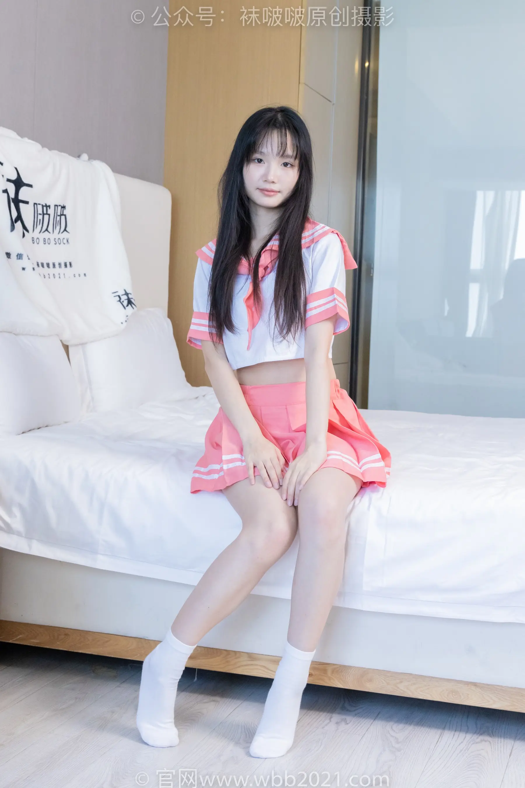 一个穿着裙子坐在床上的女人的特写
