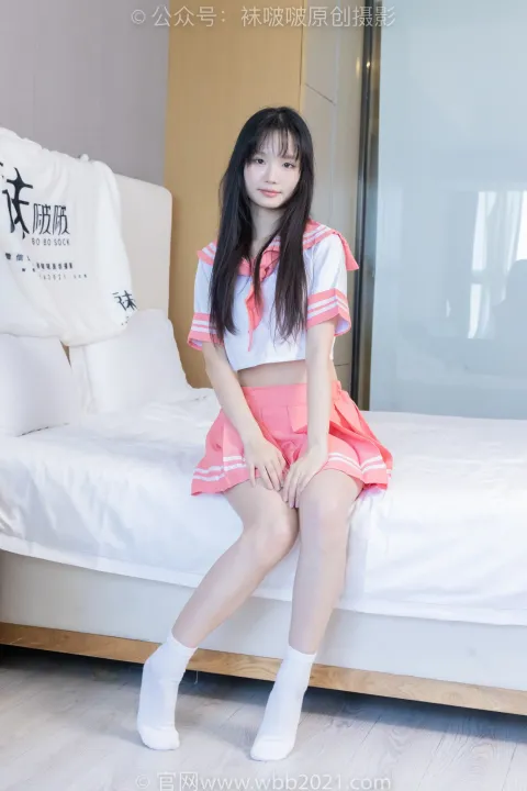 一个穿着裙子坐在床上的女人的特写