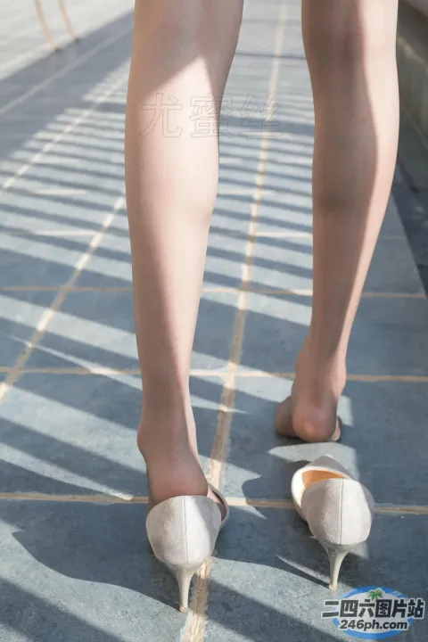 人行道上有个穿着高跟鞋的女人的腿