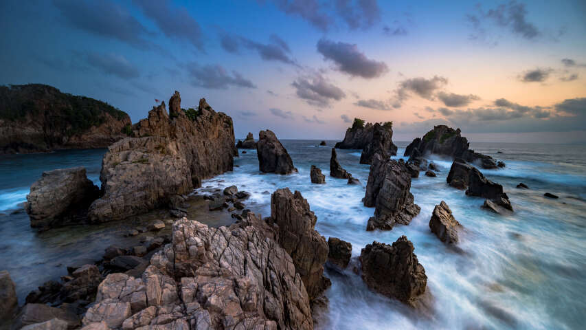 日落时分，海浪拍打岩石的岩石海岸