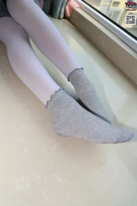 有个女人穿着袜子坐在窗台上