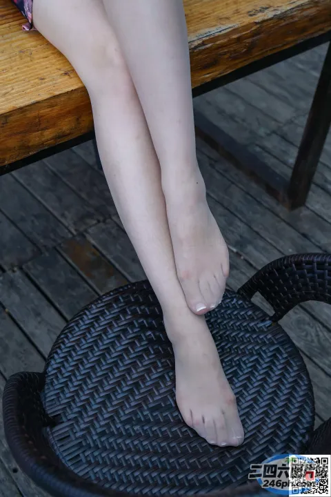 有个女人坐在椅子上，脚放在桌子上