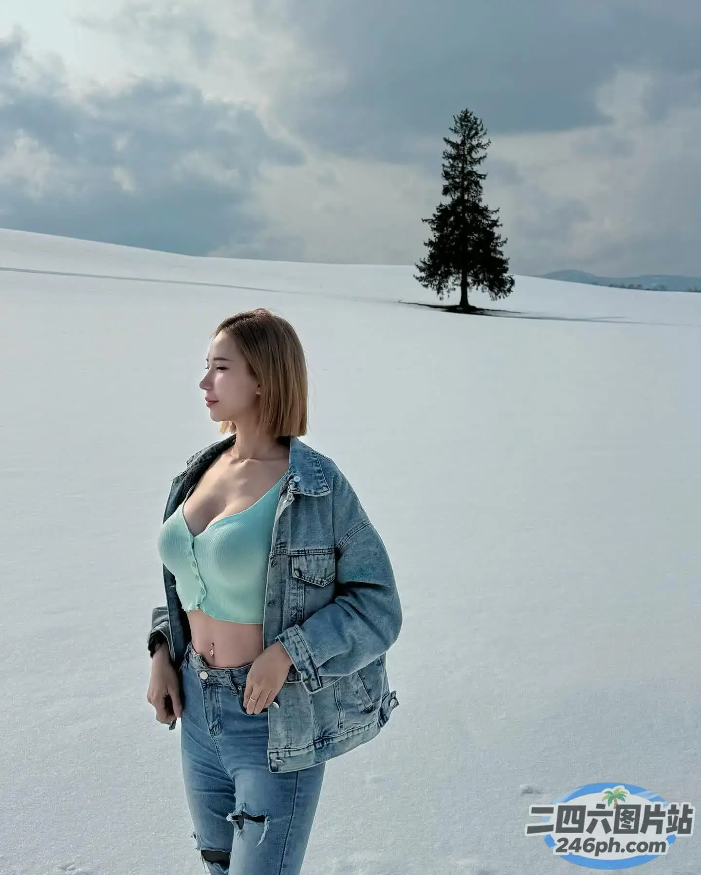 阿拉费德女人站在雪地里，背景是一棵树