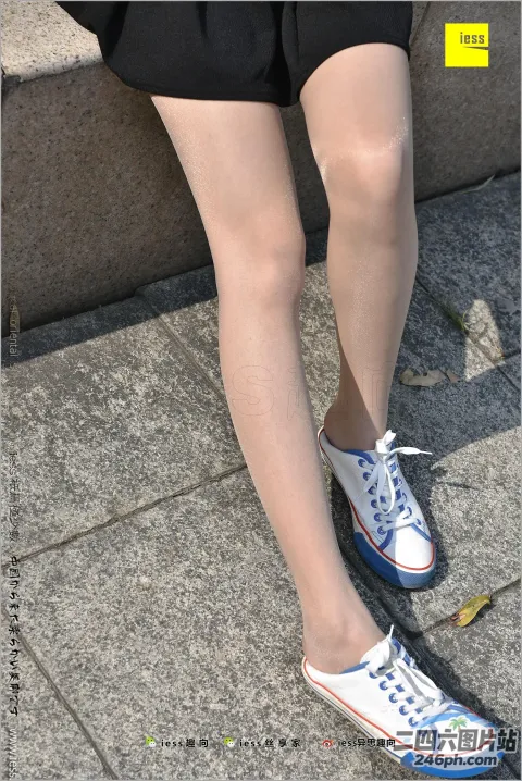 人行道上有一个穿着白色和蓝色鞋子的女人