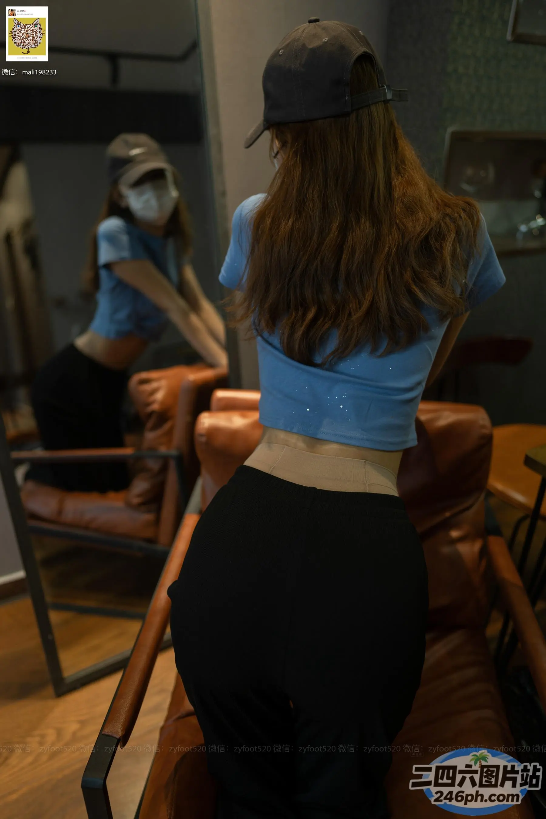 有一位女士戴着棒球帽站在椅子上