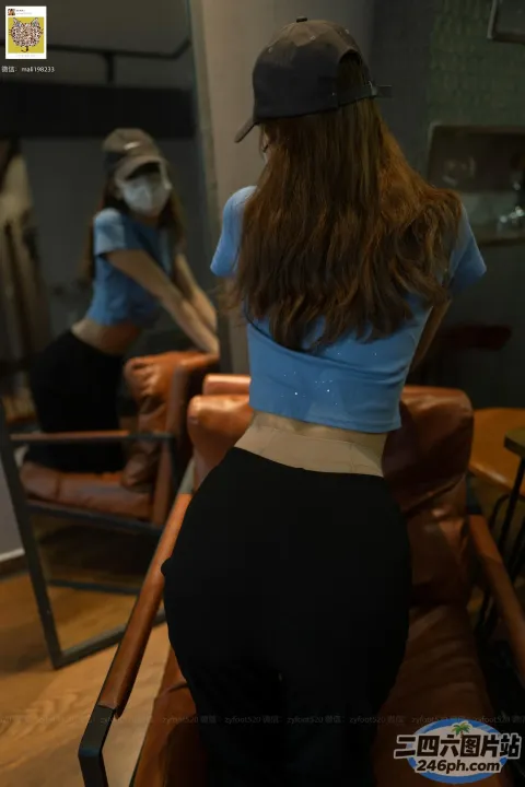 有一位女士戴着棒球帽站在椅子上