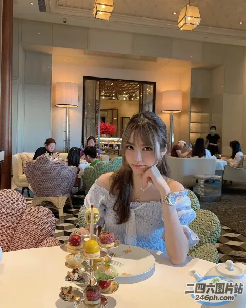有个女人坐在一张桌子旁，桌上放着一盘食物
