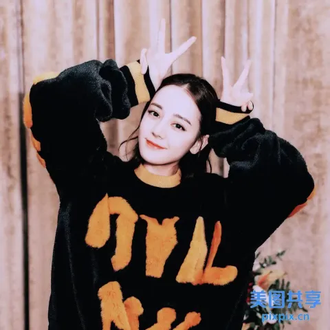 有一位穿着黑橙色毛衣摆姿势拍照的女人