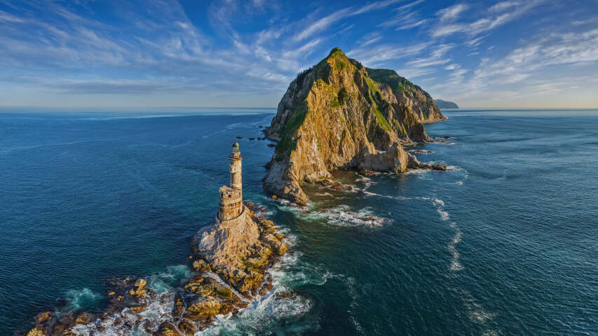 海洋中的 Arafed 岩层，顶部有灯塔