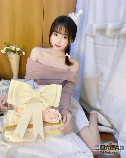 身穿粉红色连衣裙的 araffe 女子坐在床上，手里拿着一盒纸杯蛋糕