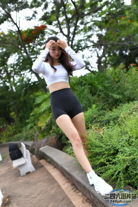 身穿白色上衣和黑色短裤的 araffe 亚洲女性在窗台上摆姿势