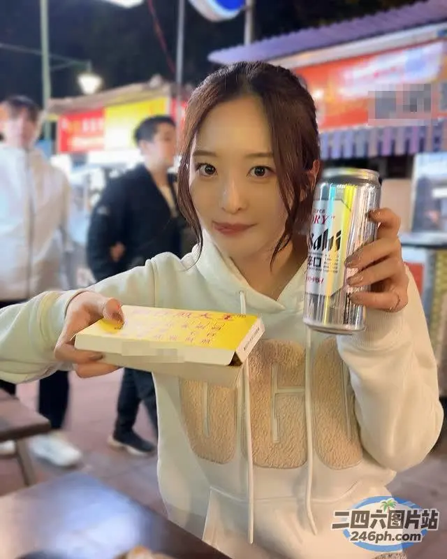 拿着一罐苏打水和一盒甜甜圈的女人