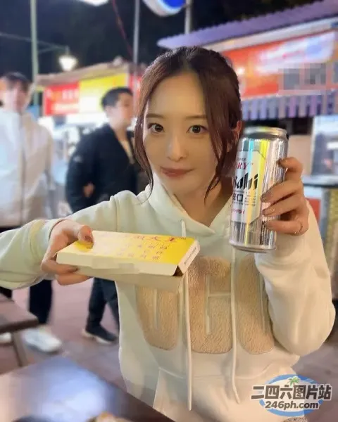 拿着一罐苏打水和一盒甜甜圈的女人
