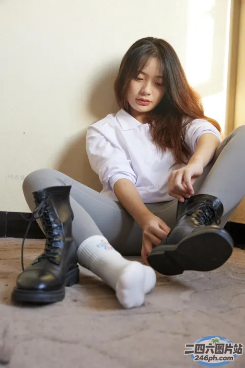 阿拉菲女子坐在地板上，双叉，穿着鞋子