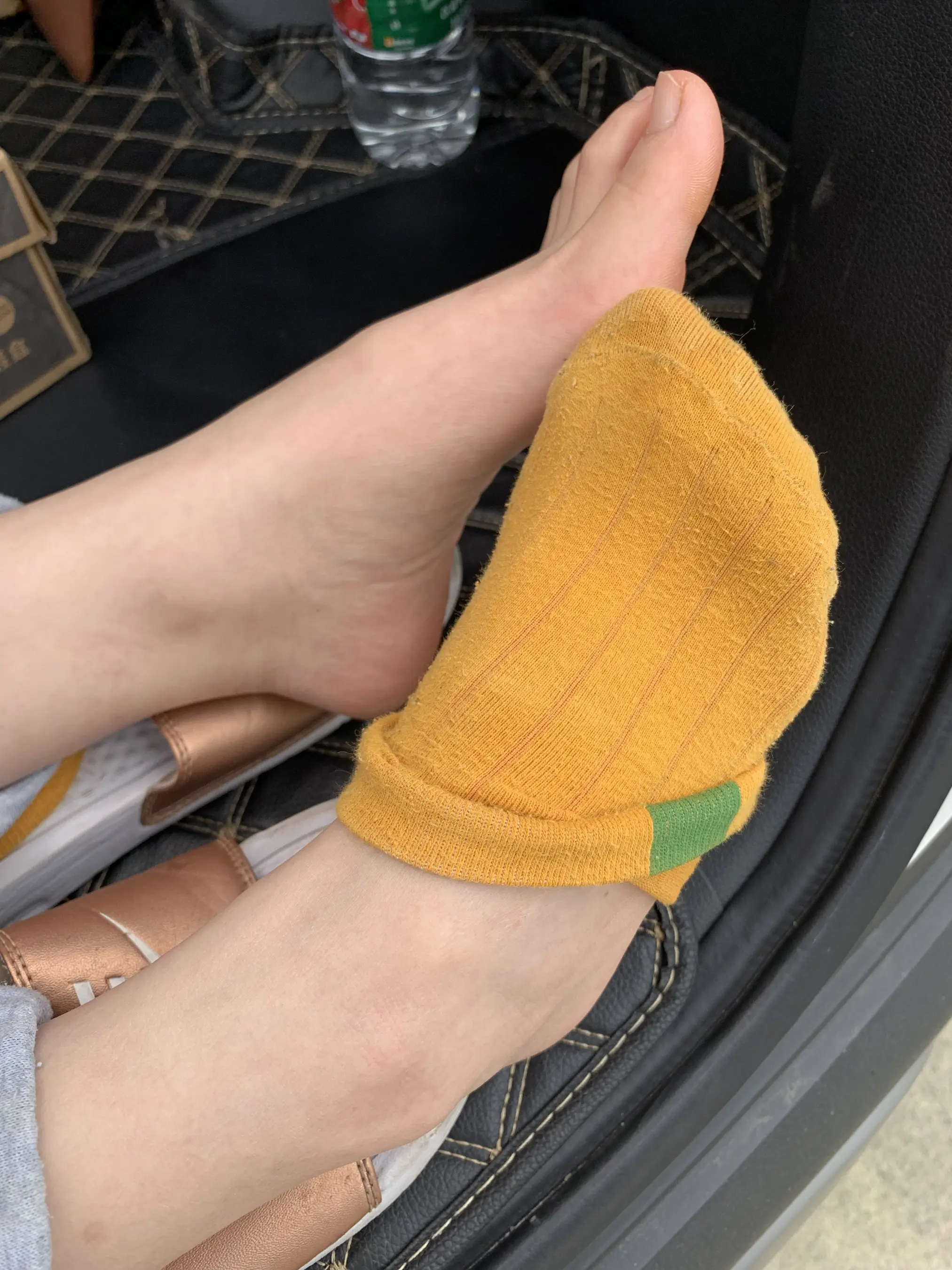有人坐在汽车后座上，双脚抬起