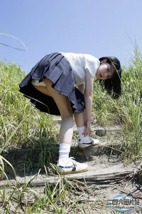 有一个女孩弯腰在草地上捡东西