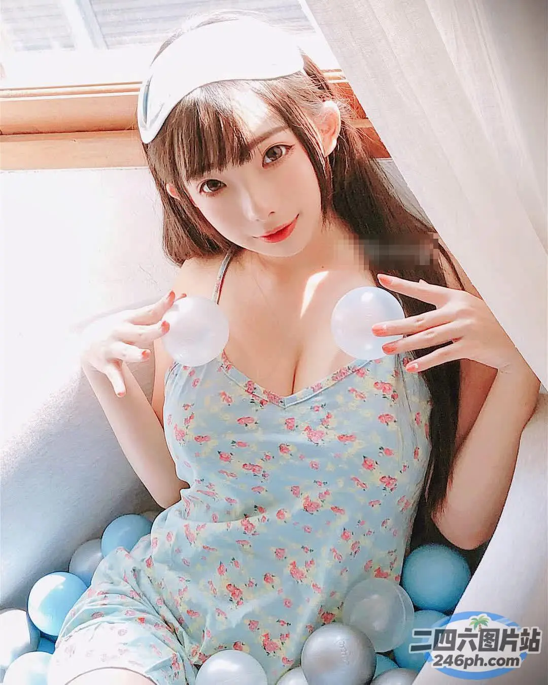 穿着蓝色连衣裙的 arafed 亚洲女人坐在球床上