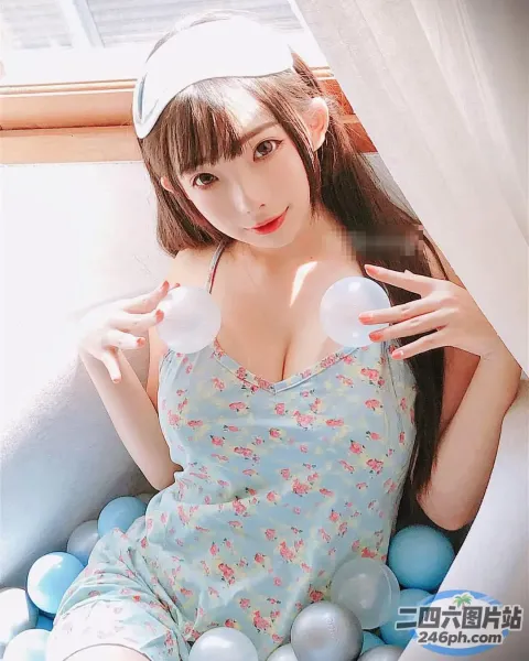 穿着蓝色连衣裙的 arafed 亚洲女人坐在球床上