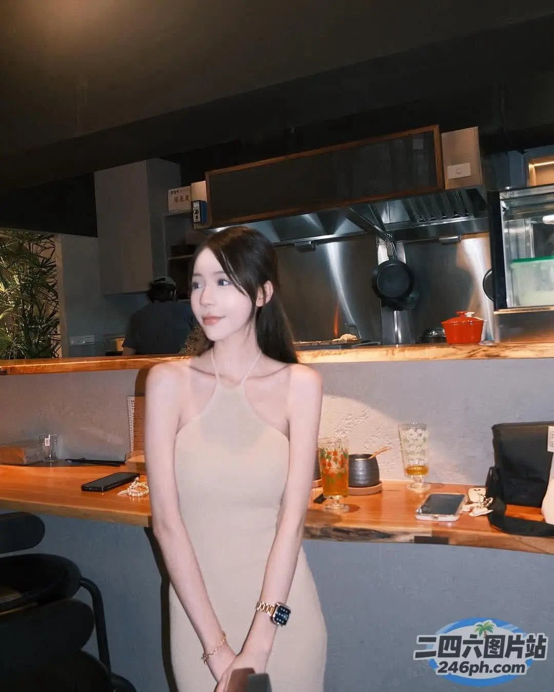 穿着棕褐色连衣裙的女人站在带柜台的厨房里
