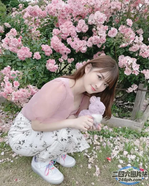跪在一丛粉红色花朵前的 araffe 女孩