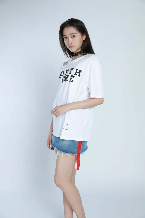 身穿白衬衫和蓝色牛仔裙的女子摆姿势拍照