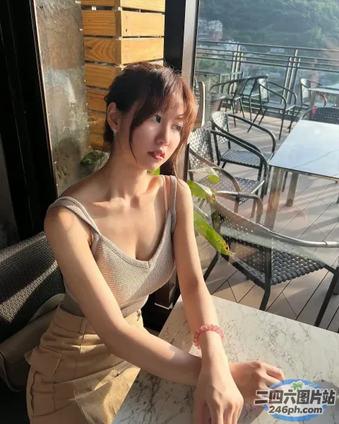 有个女人坐在桌子旁，手里拿着一本书